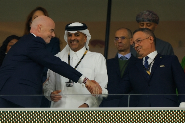 Le président de la Fédération royale marocaine de football, Fouzi Lekjâa, à droite, serre la main du président de la FIFA, Gianni Infantino, devant le premier ministre qatari Khalid bin Khalifa bin Abdulaziz al-Thani, lors du quart de finale de la Coupe du monde opposant le Maroc au Portugal.